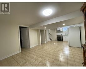 A spacious room with beige tiled flooring and a white door.
