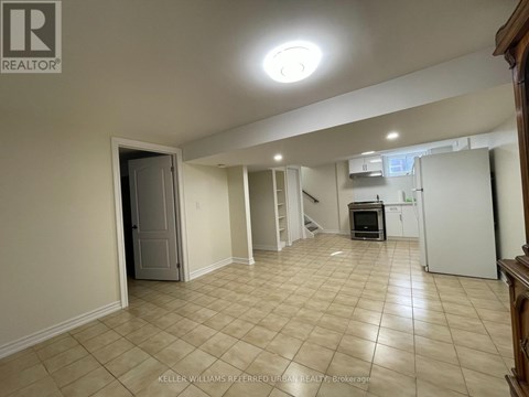 A spacious room with beige tiled flooring and a white door.