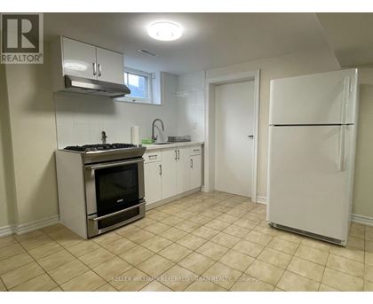 A kitchen with a stove top oven and a refrigerator.
