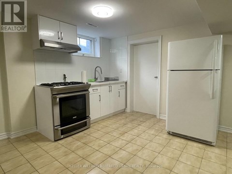 A kitchen with a stove top oven and a refrigerator.