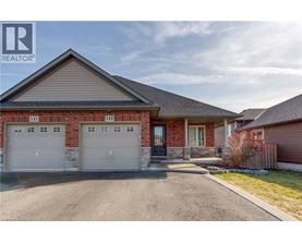 A house with a garage and a driveway in front of it.