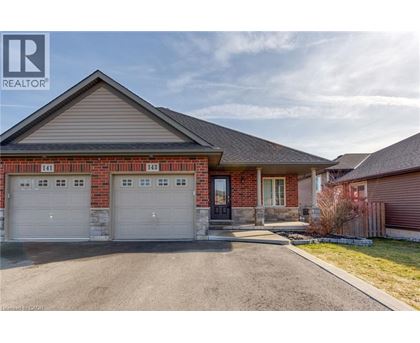 A house with a garage and a driveway in front of it.