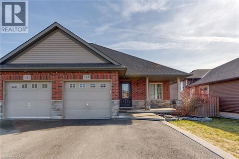A house with a garage and a driveway in front of it.