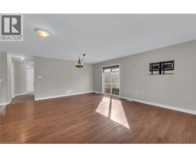 A large empty room with wooden floors and a chandelier.