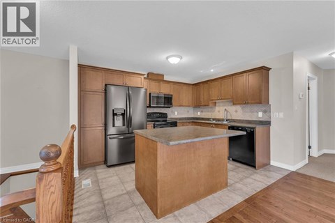 A kitchen with wooden cabinets and a large island.