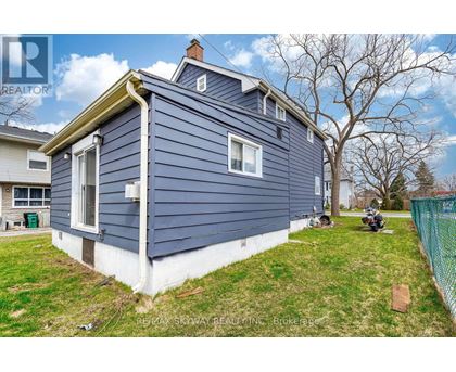 A blue house with a white trim is for sale.