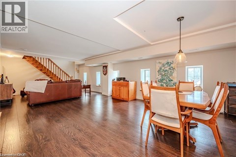 A living room with a couch, chairs, and a dining table.