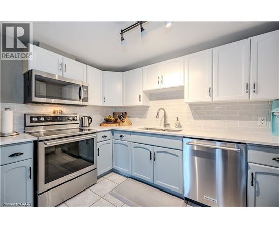 A kitchen with white cabinets and stainless steel appliances.
