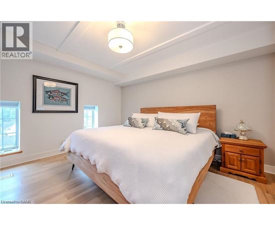 A bedroom with a large bed and a wooden headboard.