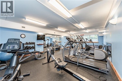 A gym with a variety of equipment including treadmills, elliptical machines, and weights.