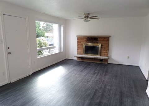 A room with a fireplace and a ceiling fan.