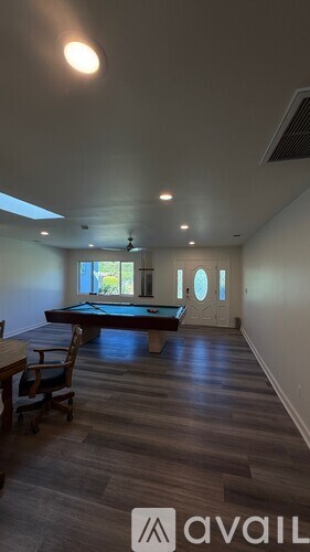 A room with a pool table and a chair.