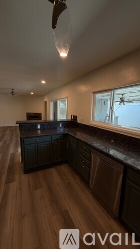 A kitchen with dark wood cabinets and a ceiling fan.