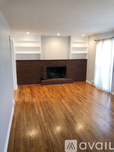 A room with a fireplace and wooden floors.