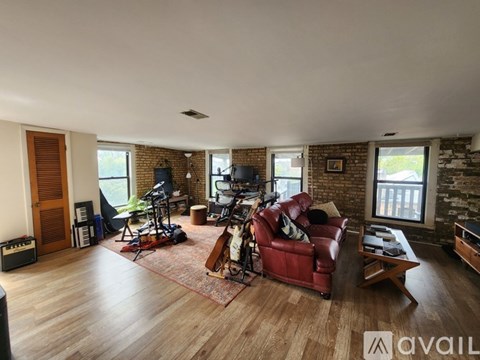 A living room with a red couch and a wooden floor.