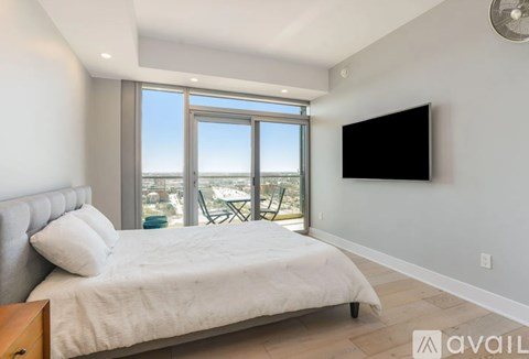 A bedroom with a large bed and a flat screen TV mounted on the wall.