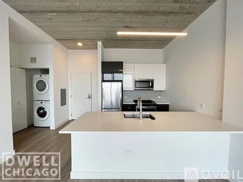 A modern kitchen with white appliances and a wooden floor.