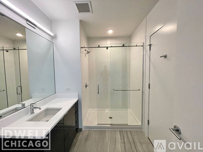 A modern bathroom with a walk-in shower and a double sink vanity.