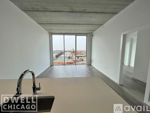 A kitchen with a sink and a window overlooking a cityscape.