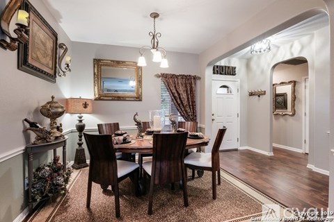 A dining room with a table set for six.