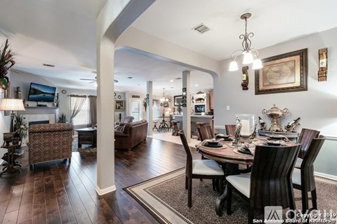 A well-lit, spacious dining room with a large table and chairs.