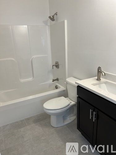 A white toilet sits in a bathroom next to a sink.