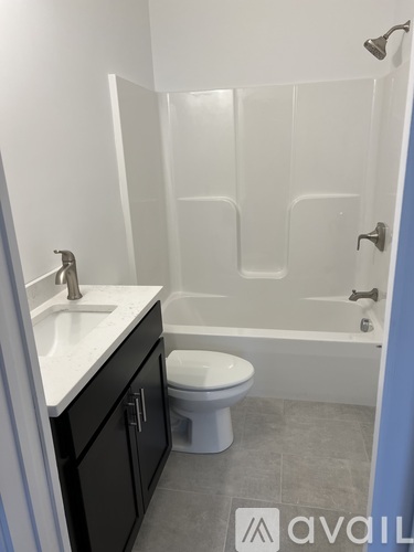 A bathroom with a toilet, sink, and bathtub.