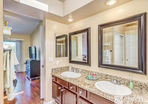 A bathroom with two sinks and a large mirror.