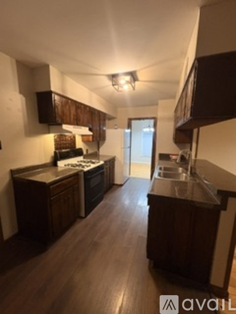 A kitchen with dark wood cabinets and a countertop.