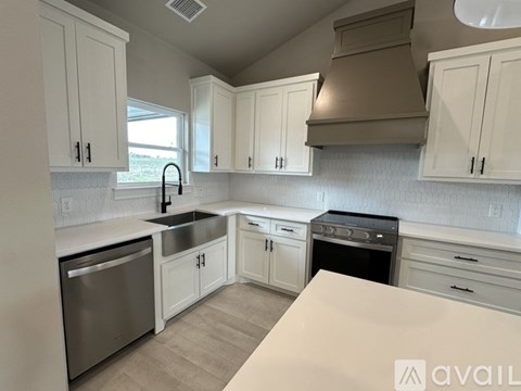 A kitchen with white cabinets and a stainless steel dishwasher.