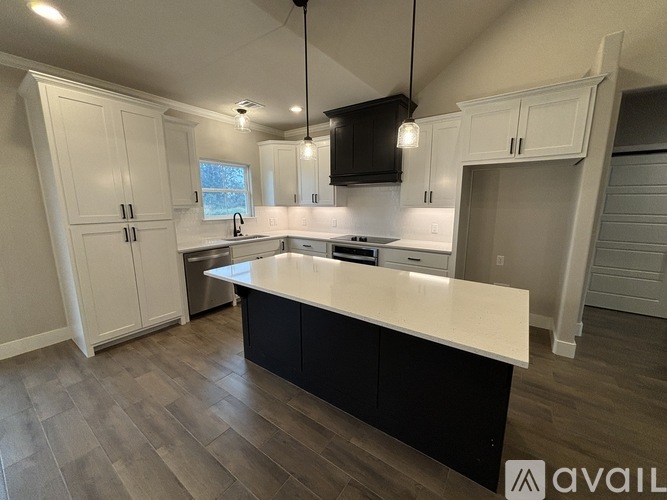 A kitchen with a white countertop and black cabinets.