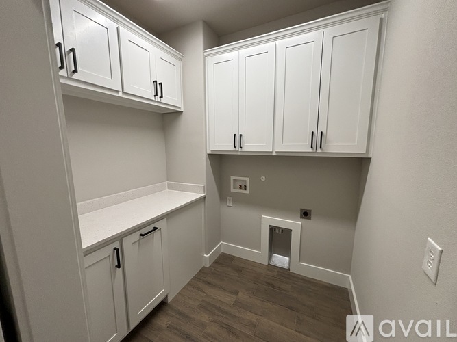 A kitchen with white cabinets and a wooden floor.