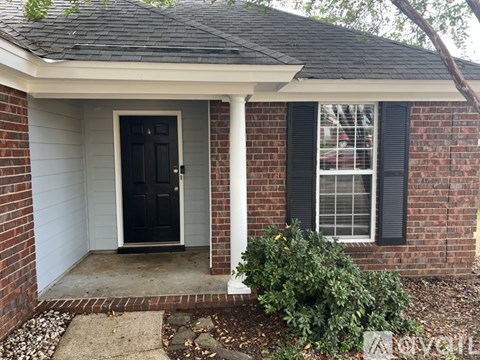 A house with a black door and a window with black shutters.
