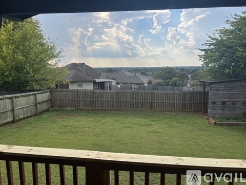 A backyard with a wooden fence and a grassy area.