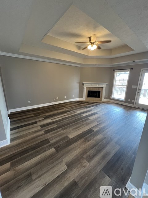 A room with wooden flooring and a ceiling fan.