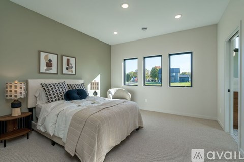 A bedroom with a large bed and a window overlooking a cityscape.