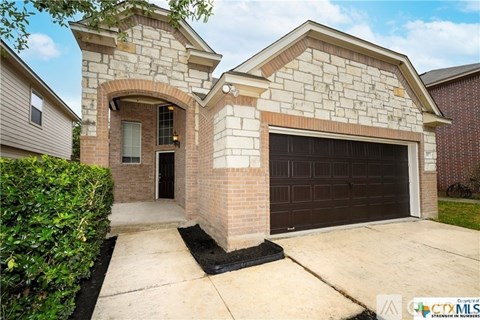 A two-story house with a garage and a brick archway entrance.