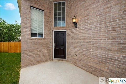 A house with a black door and a window is shown.