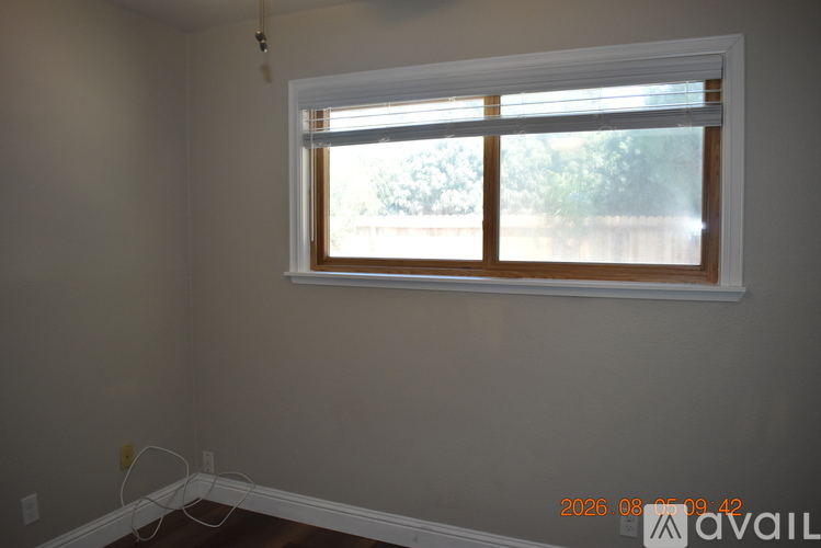 A room with a window and a white baseboard.