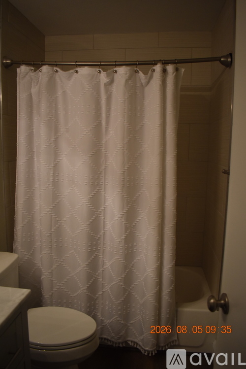 A white shower curtain in a bathroom.