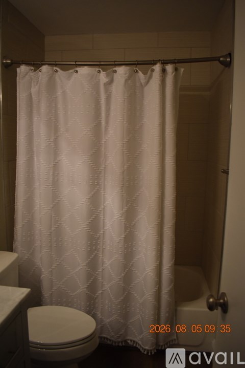 A white shower curtain in a bathroom.