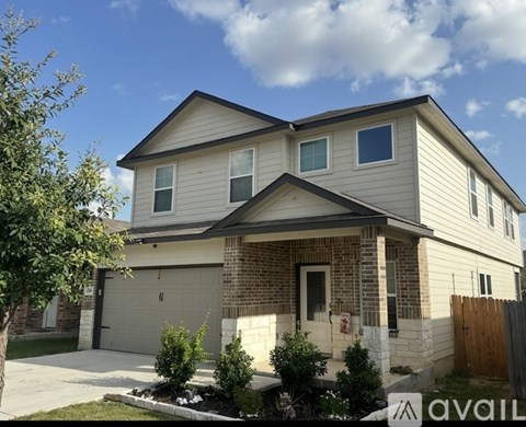 A two-story house with a garage and a brick facade.