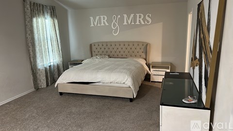 A bedroom with a large bed and a dresser with a mirror.