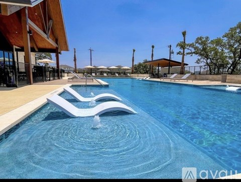 A large swimming pool with a fountain in the middle.