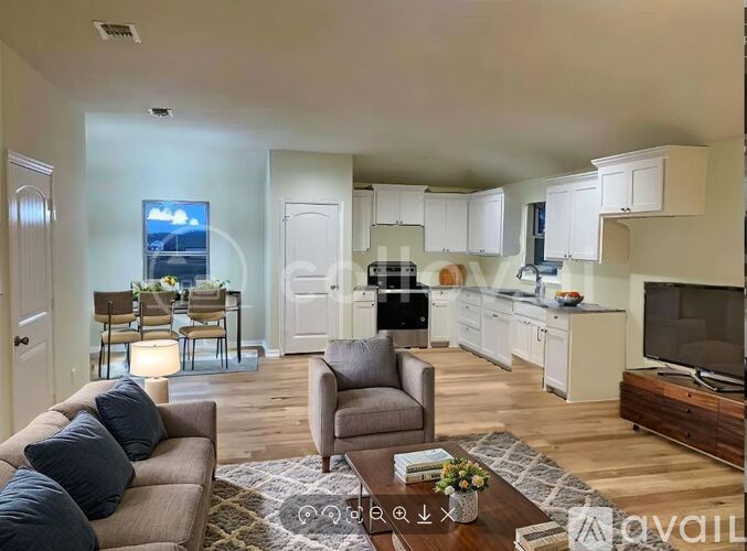 A living room with a couch, chairs, and a television.
