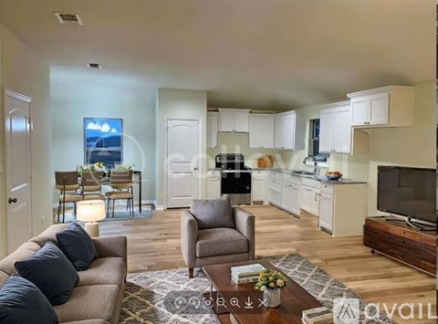 A living room with a couch, chairs, and a television.