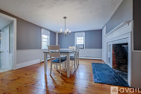 A dining room with a wooden table and chairs.