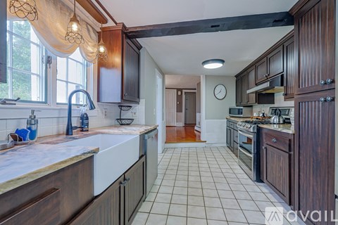 A kitchen with dark wood cabinets and a white tile floor.