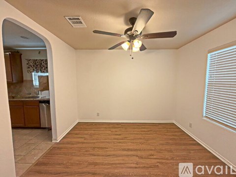 A room with a ceiling fan and wooden flooring.