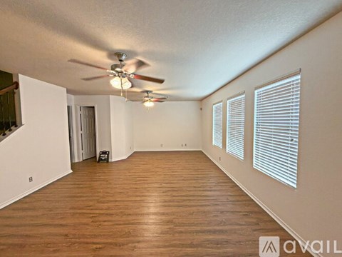 A room with a ceiling fan and wooden flooring.